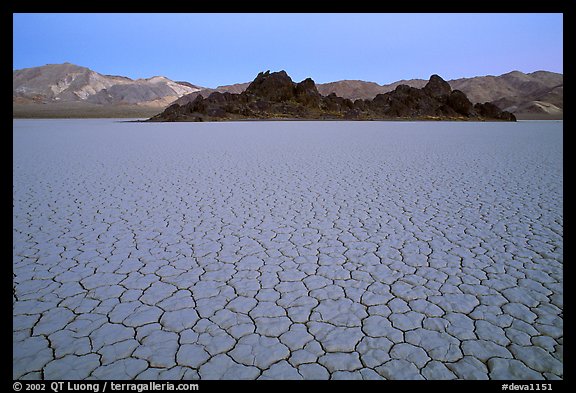 Tiles in cracked mud and Grand Stand, Racetrack playa, dusk. Death Valley National Park, California, USA.