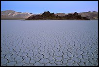 Tiles in cracked mud and Grand Stand, Racetrack playa, dusk. Death Valley National Park, California, USA. (color)