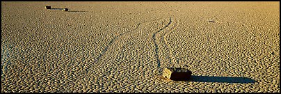 Moving stones on dried mud playa. Death Valley National Park, California, USA.