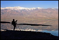 Photographer and Panamint range reflected in a seasonal lake, early morning. Death Valley National Park ( color)