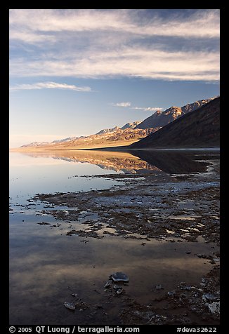 Black mountain reflections in flooded Badwater basin, early morning. Death Valley National Park, California, USA.