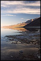 Black mountain reflections in flooded Badwater basin, early morning. Death Valley National Park, California, USA.