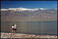 Couple watches the dragon in ephemeral lake. Death Valley National Park, California, USA.