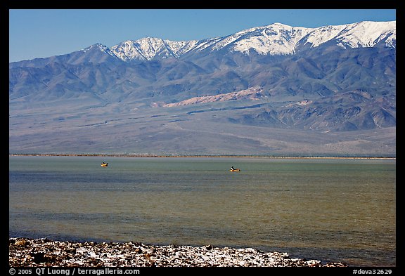 Kayakers in ephemeral Manly lake, and Panamint Range. Death Valley National Park, California, USA.