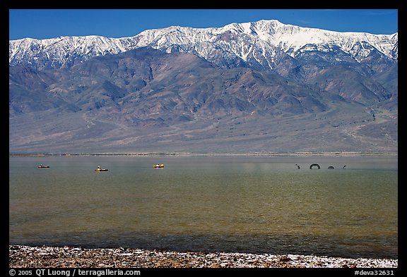 Kayakers padding towards the Loch Ness Monster in Manly Lake, below Telescope Peak. Death Valley National Park, California, USA.