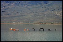 Kayakers approaching the dragon in the rare Manly Lake. Death Valley National Park, California, USA. (color)