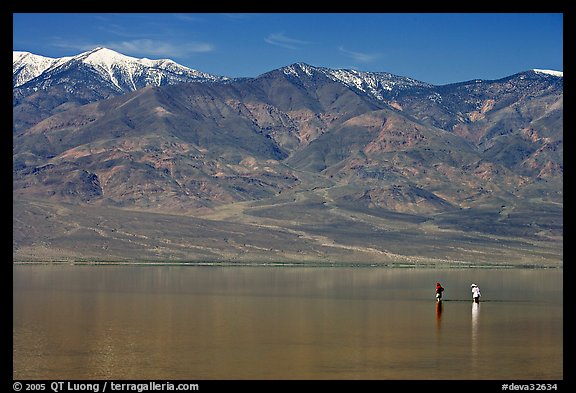 Tourists wading in the rare seasonal lake. Death Valley National Park, California, USA.