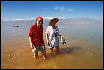 Women wading in the knee-deep seasonal lake. Death Valley National Park, California, USA.