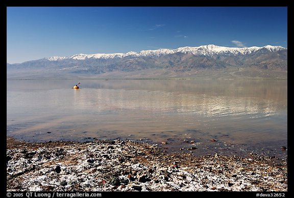 Salt formations, kayaker in a distance, and Panamint range. Death Valley National Park, California, USA.