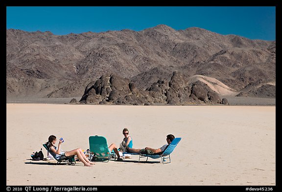 Tourists sunning themselves with beach chairs on the Racetrack. Death Valley National Park, California, USA.