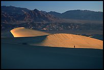 Hiker on ridge, Mesquite Dunes, sunrise. Death Valley National Park, California, USA.