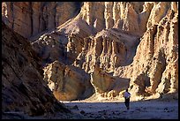 Hikers surrounded by tall walls in Golden Canyon. Death Valley National Park, California, USA.