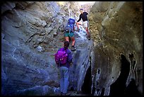 Hikers climbing in a narrow side canyon. Death Valley National Park, California, USA. (color)
