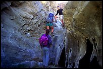 Hikers climbing in a narrow side canyon. Death Valley National Park, California, USA.