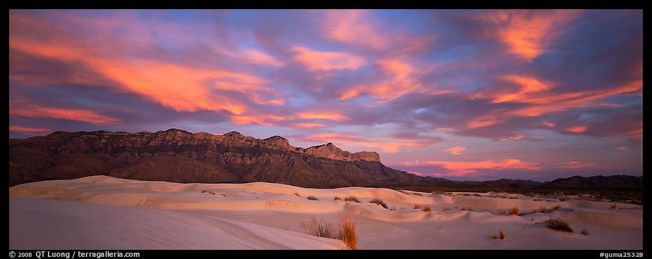 White sand dunes, mountain range, and colorful clouds. Guadalupe Mountains National Park, Texas, USA.