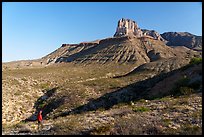 Visitor looking, dry wash below the massive limestone face of El Capitan. Guadalupe Mountains National Park ( color)
