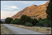 Gravel road at the base of a ridged slope glowing at sunset, Dog Canyon. Guadalupe Mountains National Park ( color)