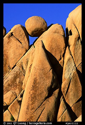 Spherical boulder jammed on top of triangular boulders, Jumbo rocks. Joshua Tree National Park, California, USA.