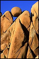 Spherical boulder jammed on top of triangular boulders, Jumbo rocks. Joshua Tree National Park, California, USA.