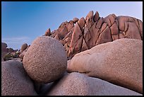 Round granite boulder and triangular rocks, dusk. Joshua Tree National Park, California, USA.