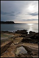 Rock slabs and sun over ocean, Schoodic Peninsula. Acadia National Park, Maine, USA.