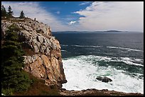 Tall granite sea cliff with person standing on top. Acadia National Park, Maine, USA.
