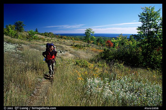 Backpacker walking on Greenstone ridge trail. Isle Royale National Park (color)