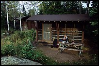 Backpacker sitting in shelter at Chippewa harbor. Isle Royale National Park ( color)