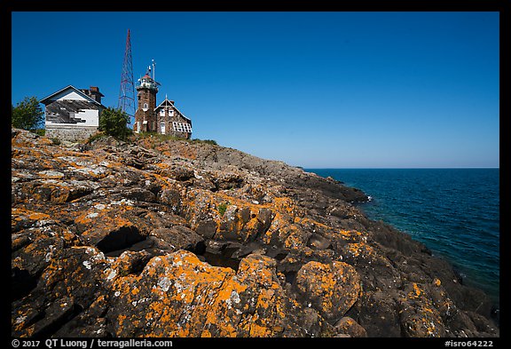 Lichen-covered rocks and Lighthouse, Passage Island. Isle Royale National Park, Michigan, USA.