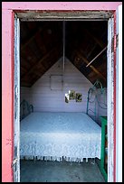Bed framed by door of single-room Honeymoon cabin, Edisen Fishery. Isle Royale National Park ( color)