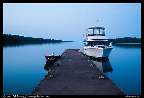 Dock with motorboat and yacht at dusk, Moskey Basin. Isle Royale National Park, Michigan, USA.