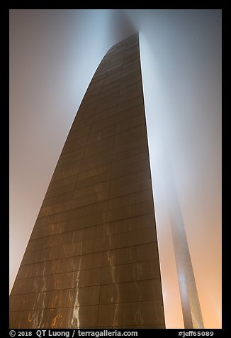 Profile view of Gateway Arch with top in clouds at night. Gateway Arch National Park, St Louis, Missouri, USA.