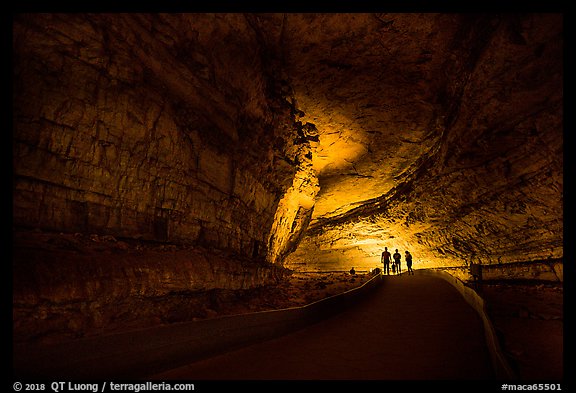 Family backlighted in dark cave corridor. Mammoth Cave National Park, Kentucky, USA.