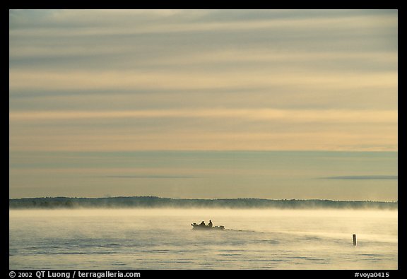 Boaters in fog, early morning, Kabetogama lake. Voyageurs National Park, Minnesota, USA.