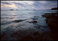 Lakeshore with eroded granite slab and clouds. Voyageurs National Park, Minnesota, USA.