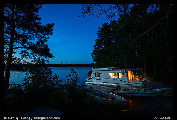 Houseboat lit from within at night, Sand Point Lake. Voyageurs National Park, Minnesota, USA.