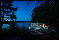 Houseboat lit from within at night, Sand Point Lake. Voyageurs National Park, Minnesota, USA.