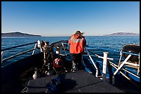 Woman standing on bow of boat sailing towards Annacapa and Santa Cruz Islands. Channel Islands National Park, California, USA. (color)