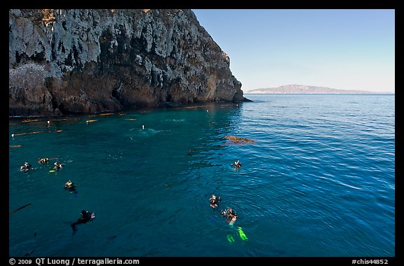 Divers, emerald waters, and steep cliffs, Annacapa island. Channel Islands National Park, California, USA.