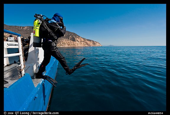 Scuba diver stepping out of boat, Santa Cruz Island. Channel Islands National Park, California, USA.