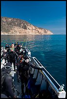 Divers in full wetsuits on diving boat, Santa Cruz Island. Channel Islands National Park, California, USA.