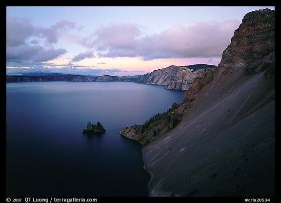 Caldera slopes and Phantom ship at dusk. Crater Lake National Park, Oregon, USA.