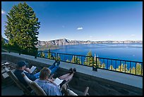 Reading on Crater Lake Lodge Terrace overlooking  Lake. Crater Lake National Park, Oregon, USA. (color)