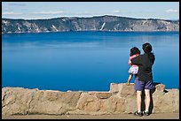 Woman and baby looking at Crater Lake. Crater Lake National Park, Oregon, USA.