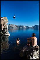 Man jumping from cliff as others look, Cleetwood Cove. Crater Lake National Park ( color)
