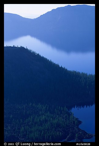 Wizard Island and crater rim profiles, early morning. Crater Lake National Park, Oregon, USA.