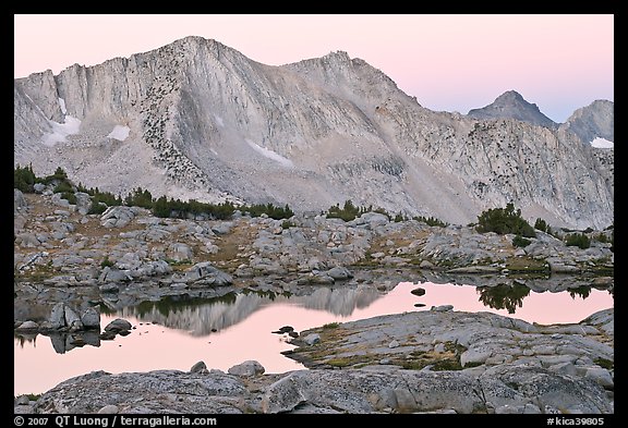 Mountains reflected in calm alpine lake at dawn, Dusy Basin. Kings Canyon National Park, California, USA.