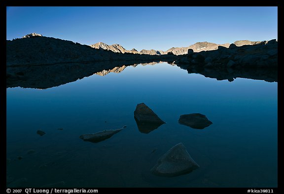 Rocks and calm lake with reflections, early morning, Dusy Basin. Kings Canyon National Park, California, USA.