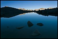 Rocks and calm lake with reflections, early morning, Dusy Basin. Kings Canyon National Park, California, USA.