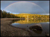 Rainbow in dark sky above Juniper Lake. Lassen Volcanic National Park, California, USA.